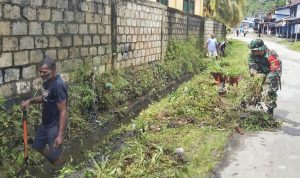 Babinsa dan Masyarakat Bersihkan Drainase Menuju Dermaga Waiya