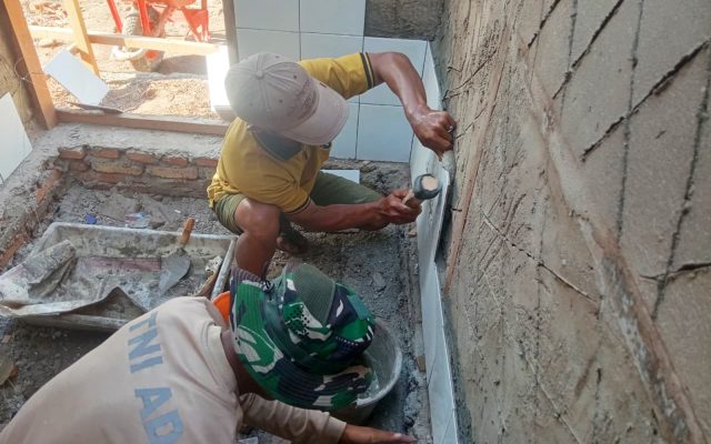 Pemasangan Dinding Keramik, Personel Satgas TMMD Percepat Pembangunan MCK di Wanam Merauke